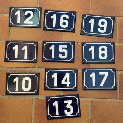 Collection of French enamel number plaques 30 through 39 with deep blue background and white numerals showing natural aging patina from decades of outdoor service on French facades