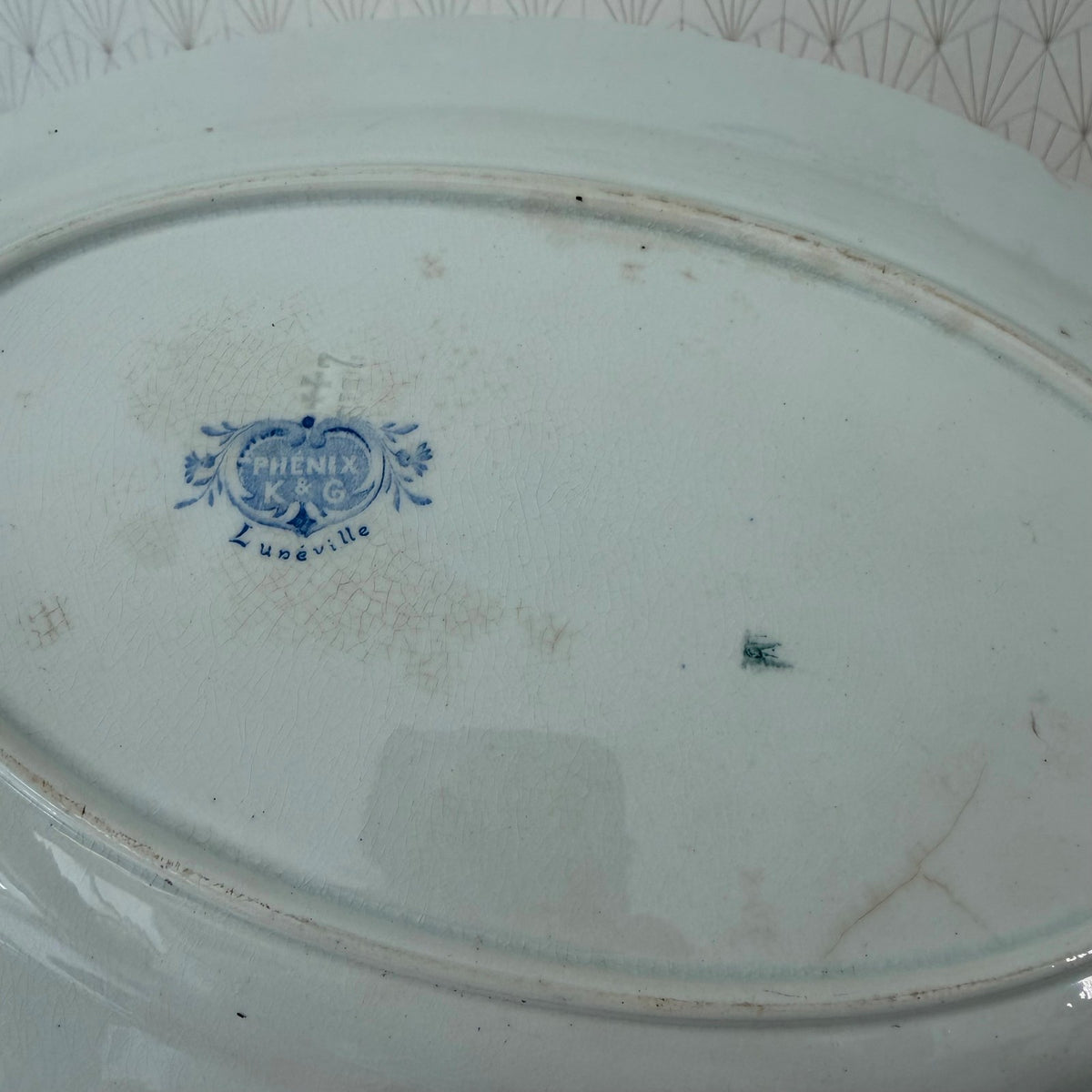 Underside of antique French Luneville platter displaying Phenix K&G pottery maker mark
