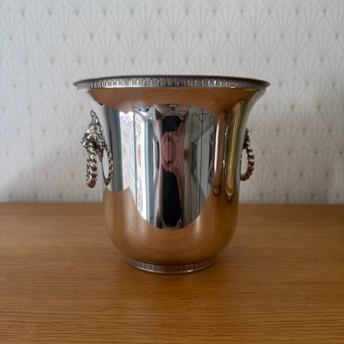 French silver plated champagne bucket with decorative lion head handles and twisted rope rings, side view showing mirror-polished body.