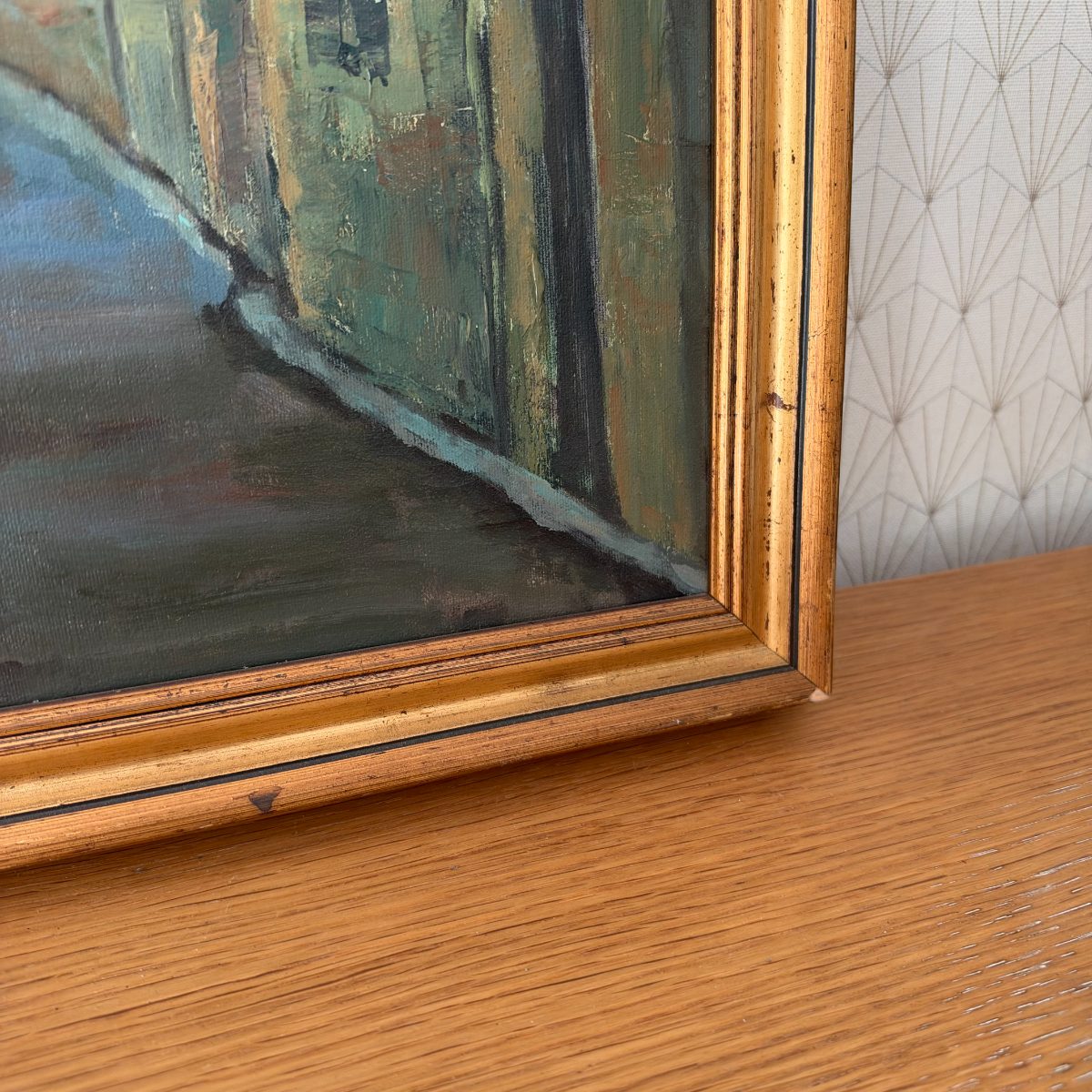 Close-up of lower right corner of gold wood frame showing age patina, thin black liner detail and canvas edge of French oil painting.
