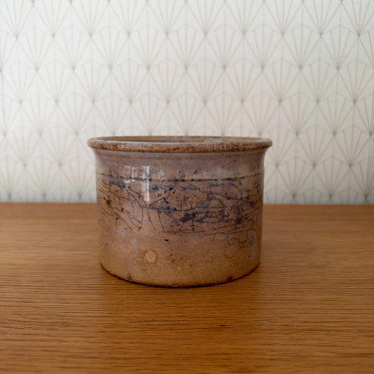 Antique French Sarreguemines stoneware crock pot, beige and blue-grey glaze with crazing, front view on oak surface.