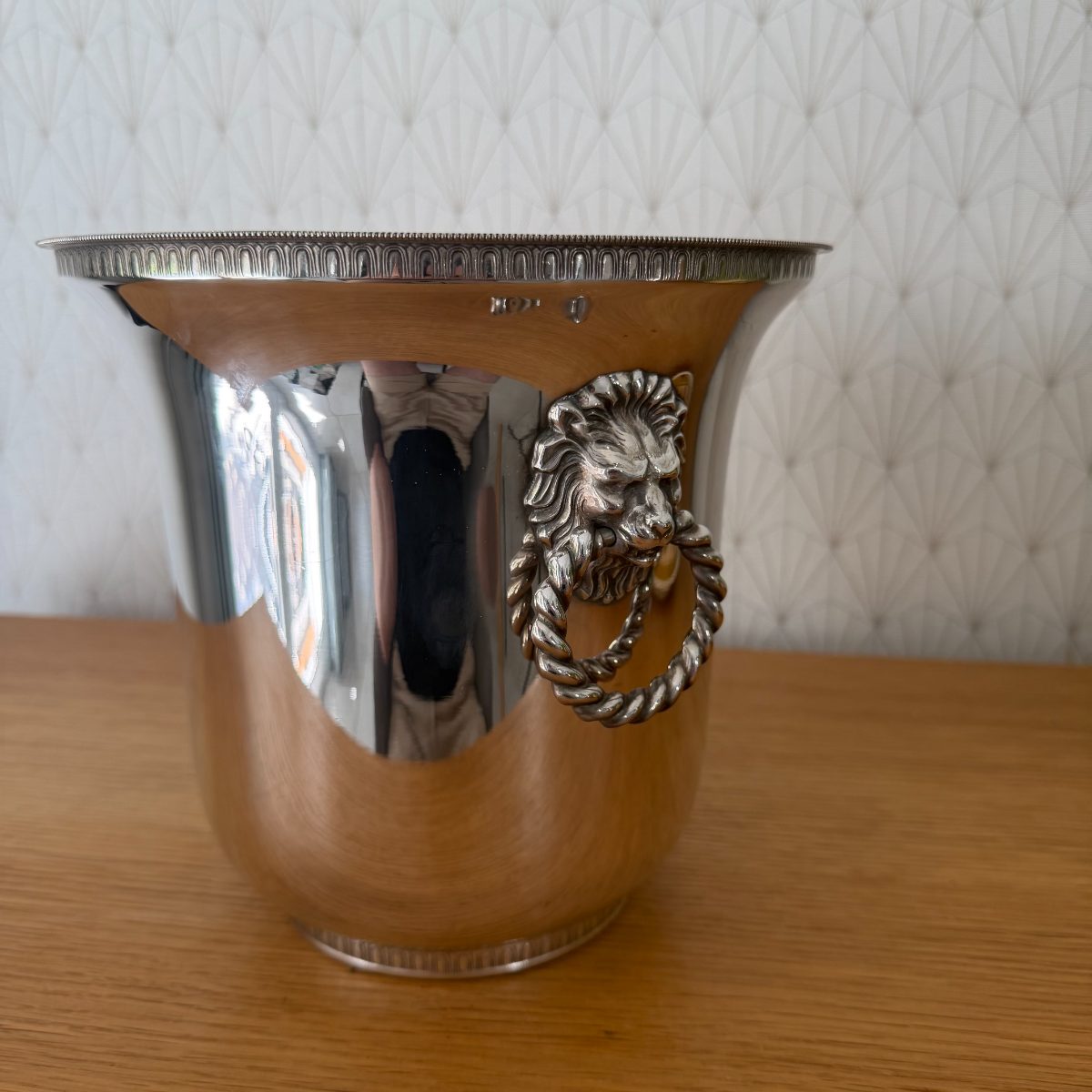 Close-up of lion head ring handle on French silver plated champagne ice bucket, showing detailed mane casting and twisted rope ring.