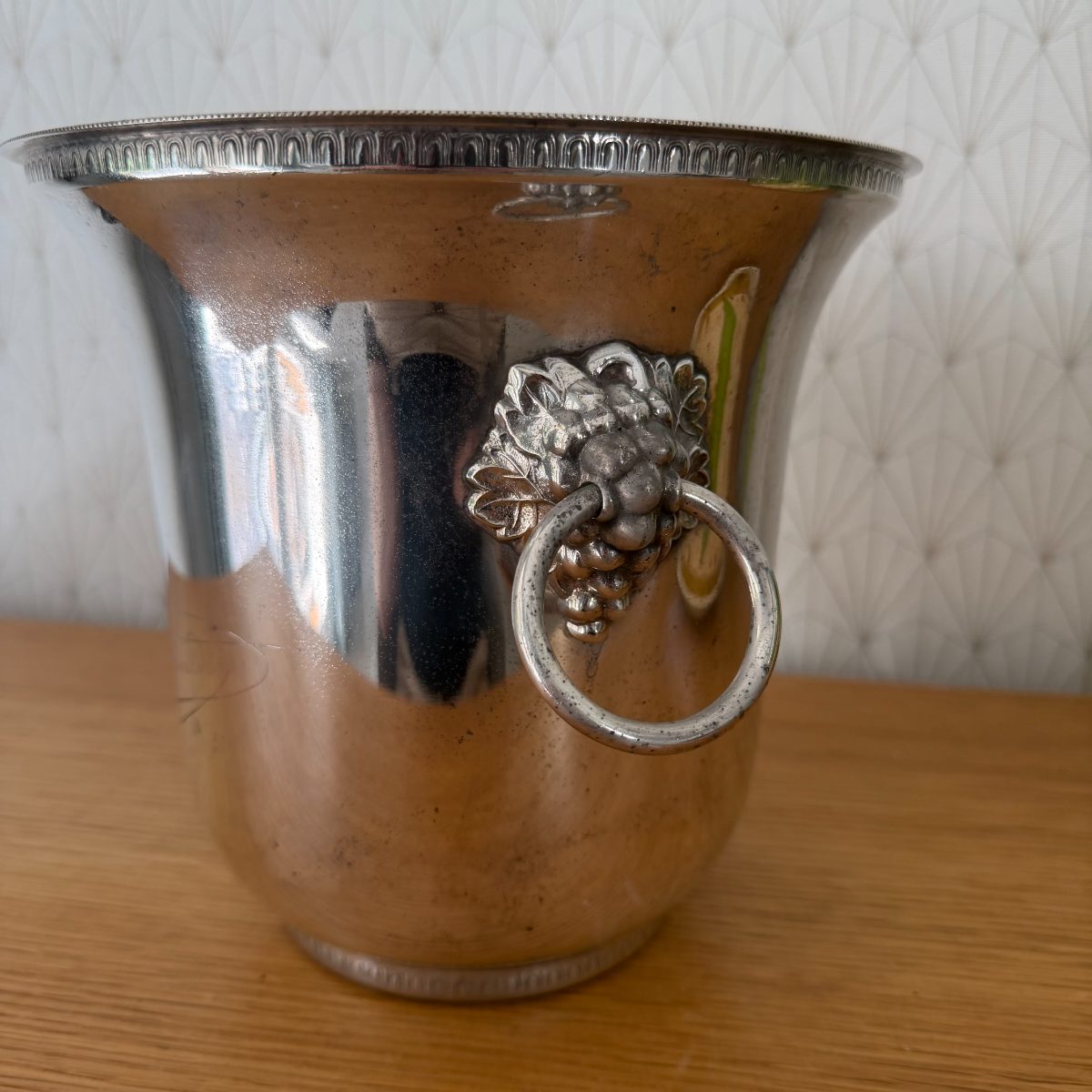 Close-up of cast silver plated lion head and ring handle on vintage French Veuve Clicquot champagne ice bucket.