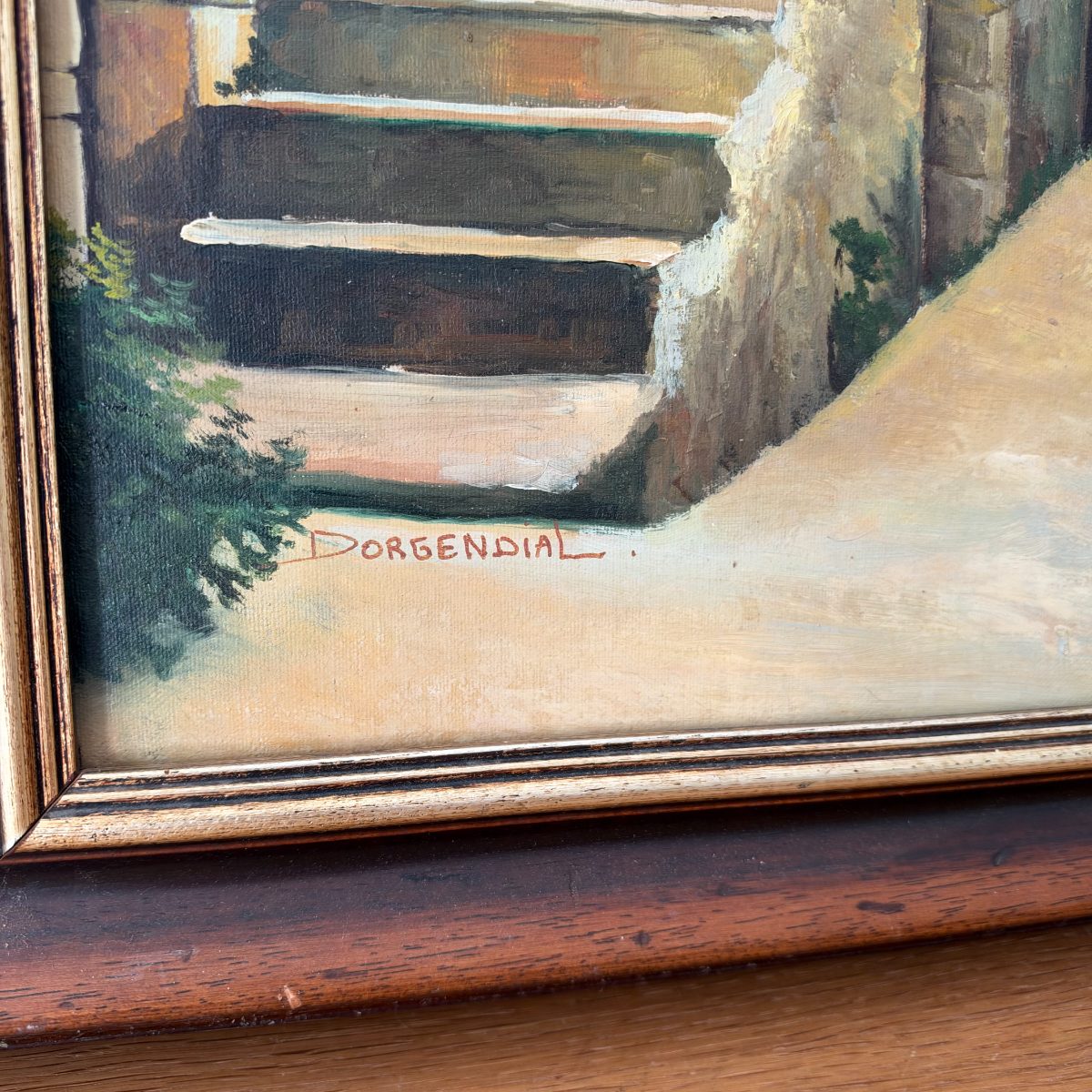 Close-up of the signature Dorgendial in red paint on the lower left of the French oil painting showing stone steps and courtyard.