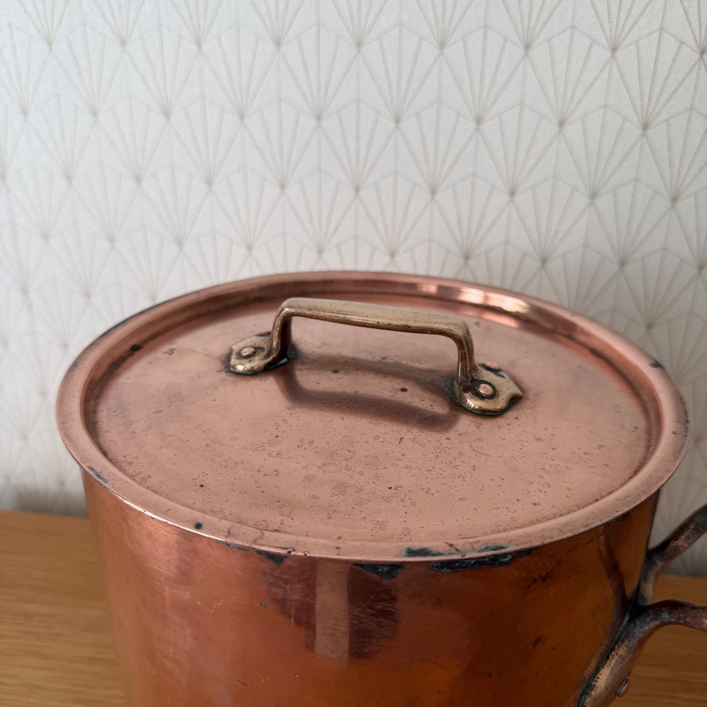 Close-up of original copper lid with brass handles, showing patina and age marks