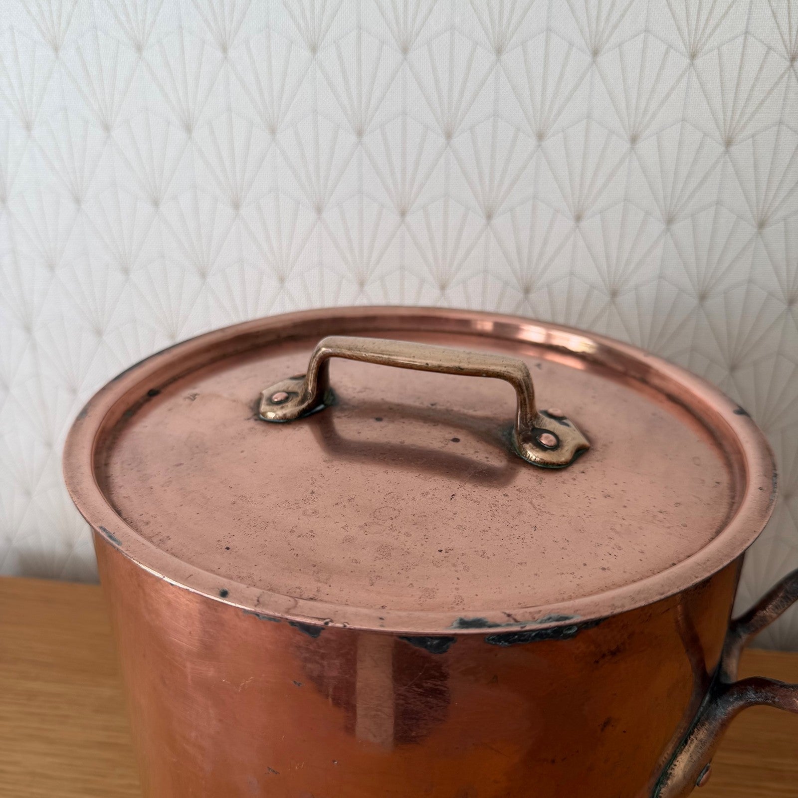 Close-up of original copper lid with brass handles, showing patina and age marks