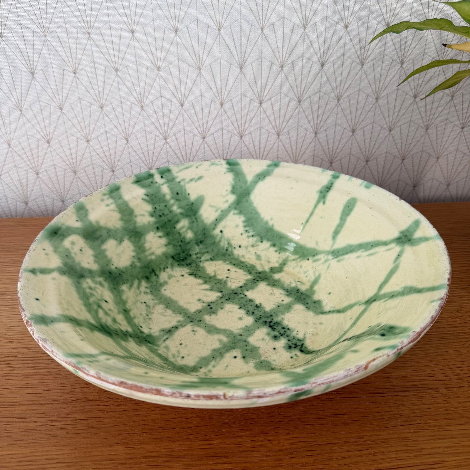 French pottery terracotta bowl interior showing green copper-oxide brushwork on cream slip