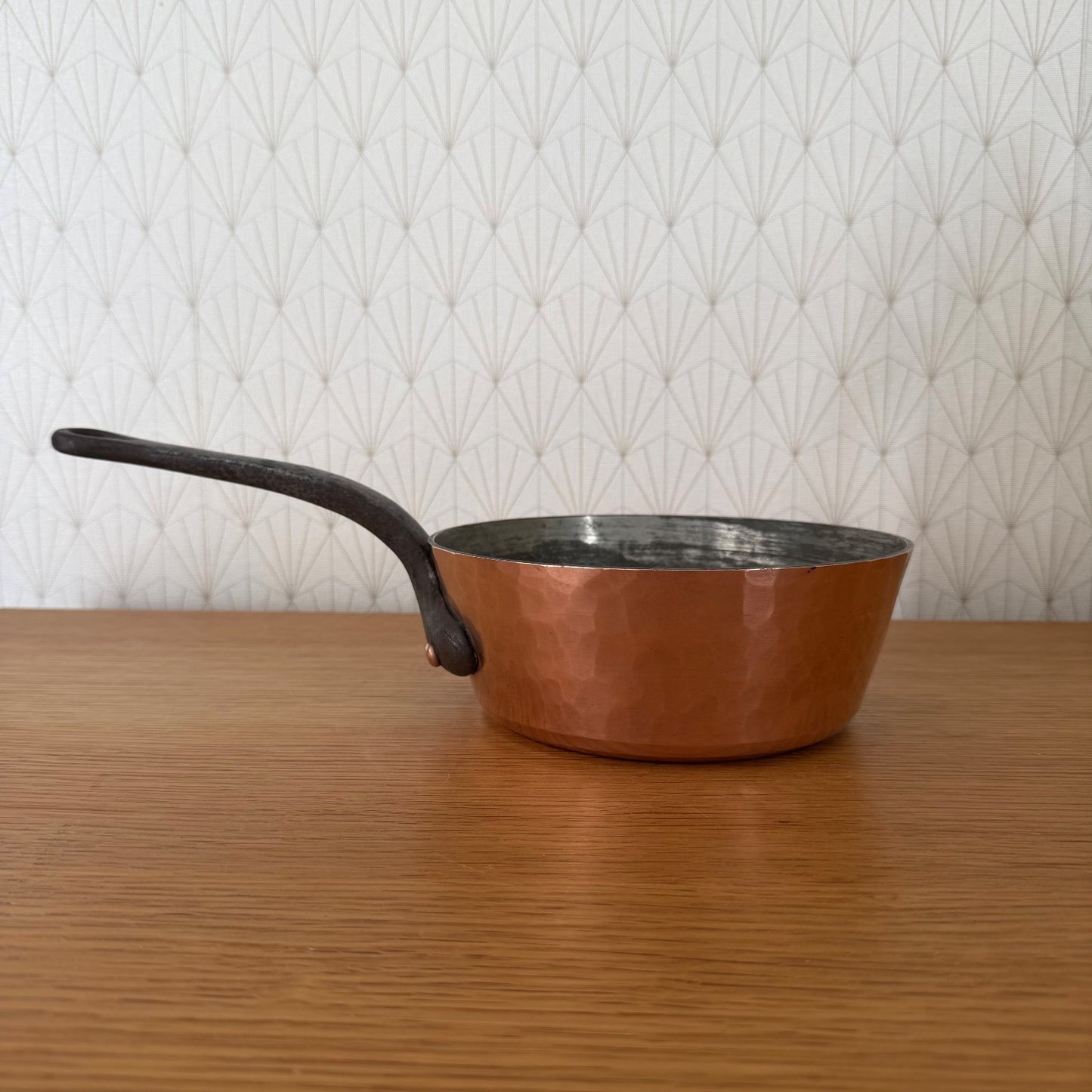 French copper sauteuse pan with curved iron handle, exterior view