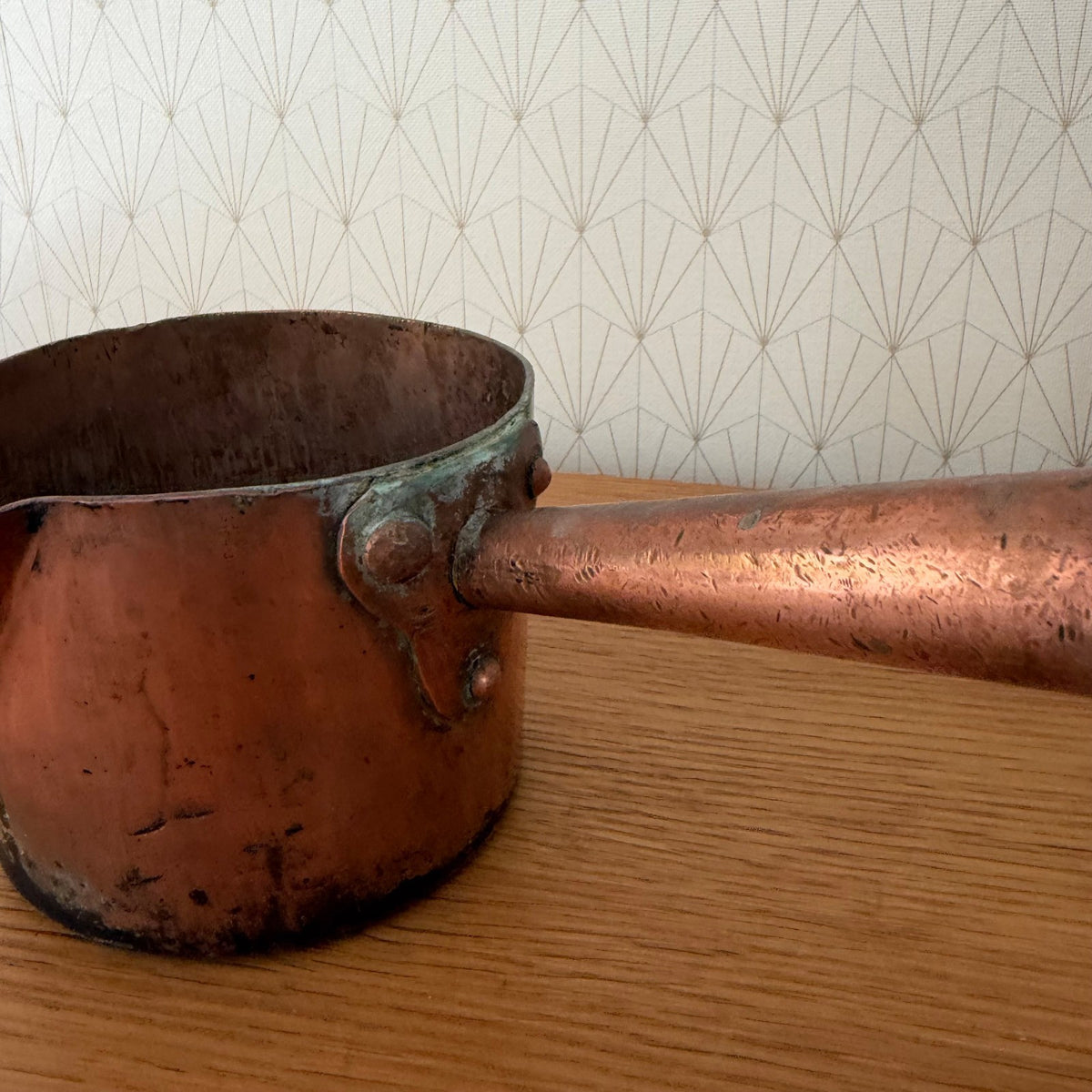 Side view French copper sugar pan with riveted wooden handle and spout detail