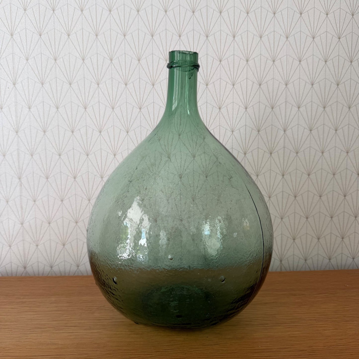Side profile of vintage French glass wine bottle demijohn with characteristic rounded form