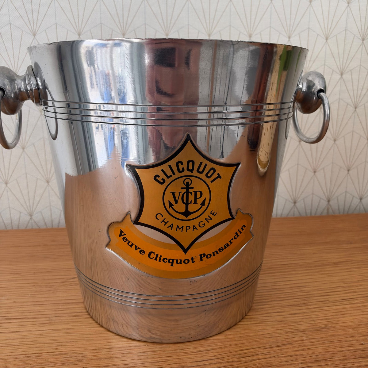 Close-up of Veuve Clicquot champagne bucket showing VCP shield crest and anchor motif on label