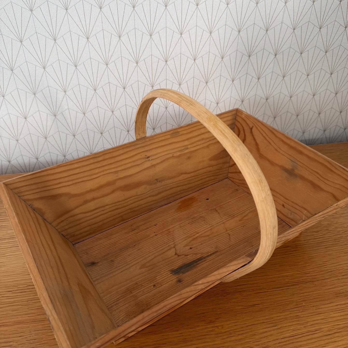 Close-up detail of French wooden garden trug showing pine wood grain and bentwood handle