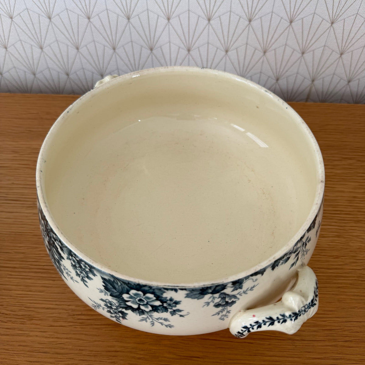 Interior of French transferware tureen showing cream-colored ironstone and blue floral rim decoration