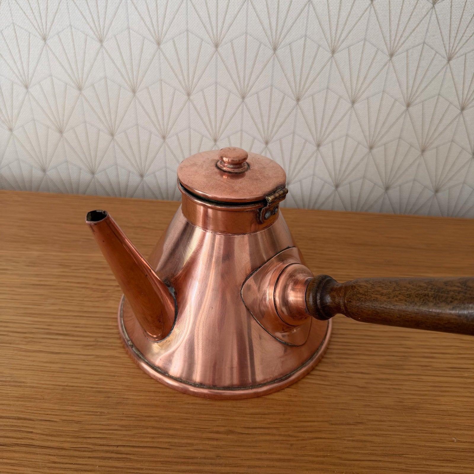 Copper cholatiere front view showing conical shape and decorative wooden handle