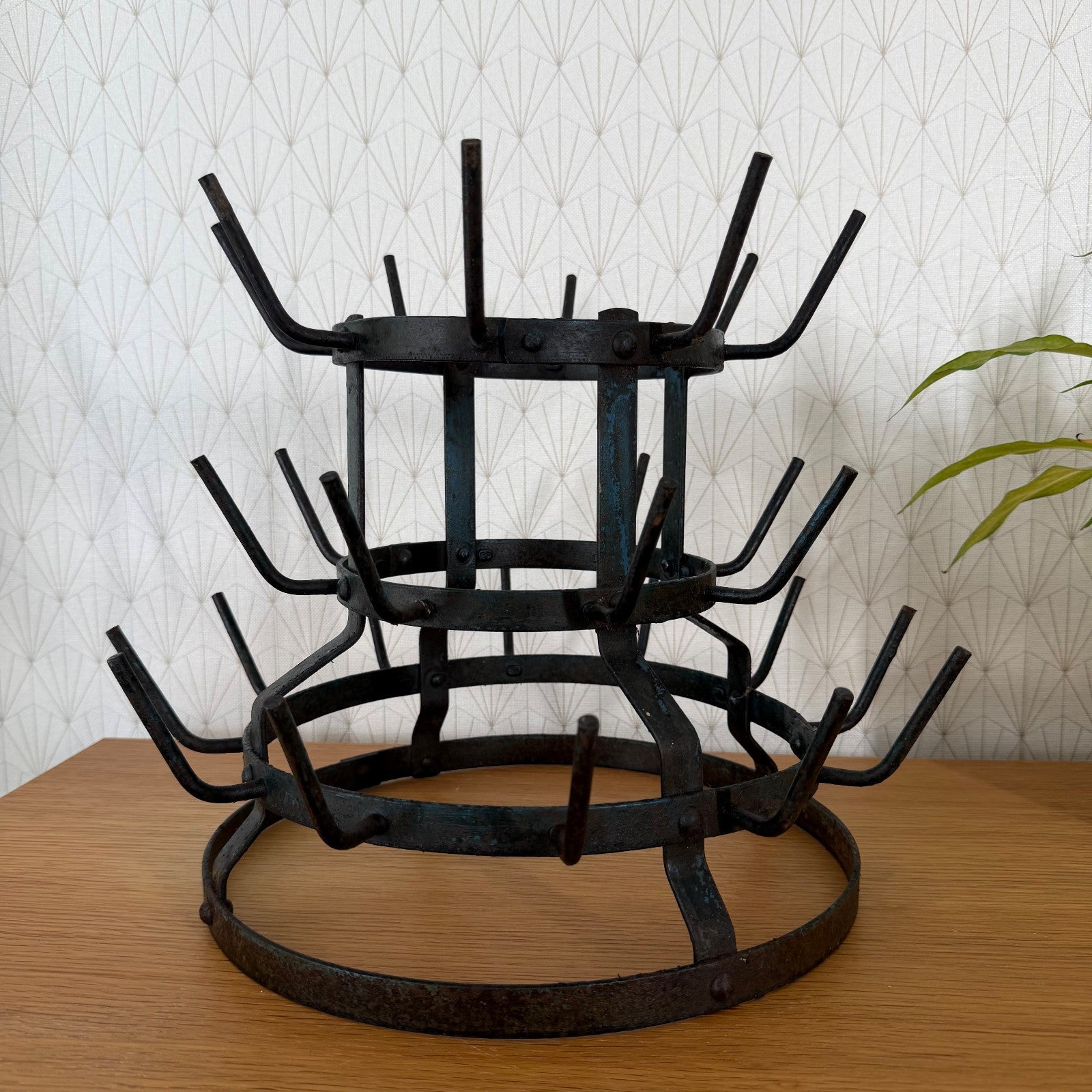 Bottom tier detail of antique French iron bottle drying rack showing base ring and foot supports