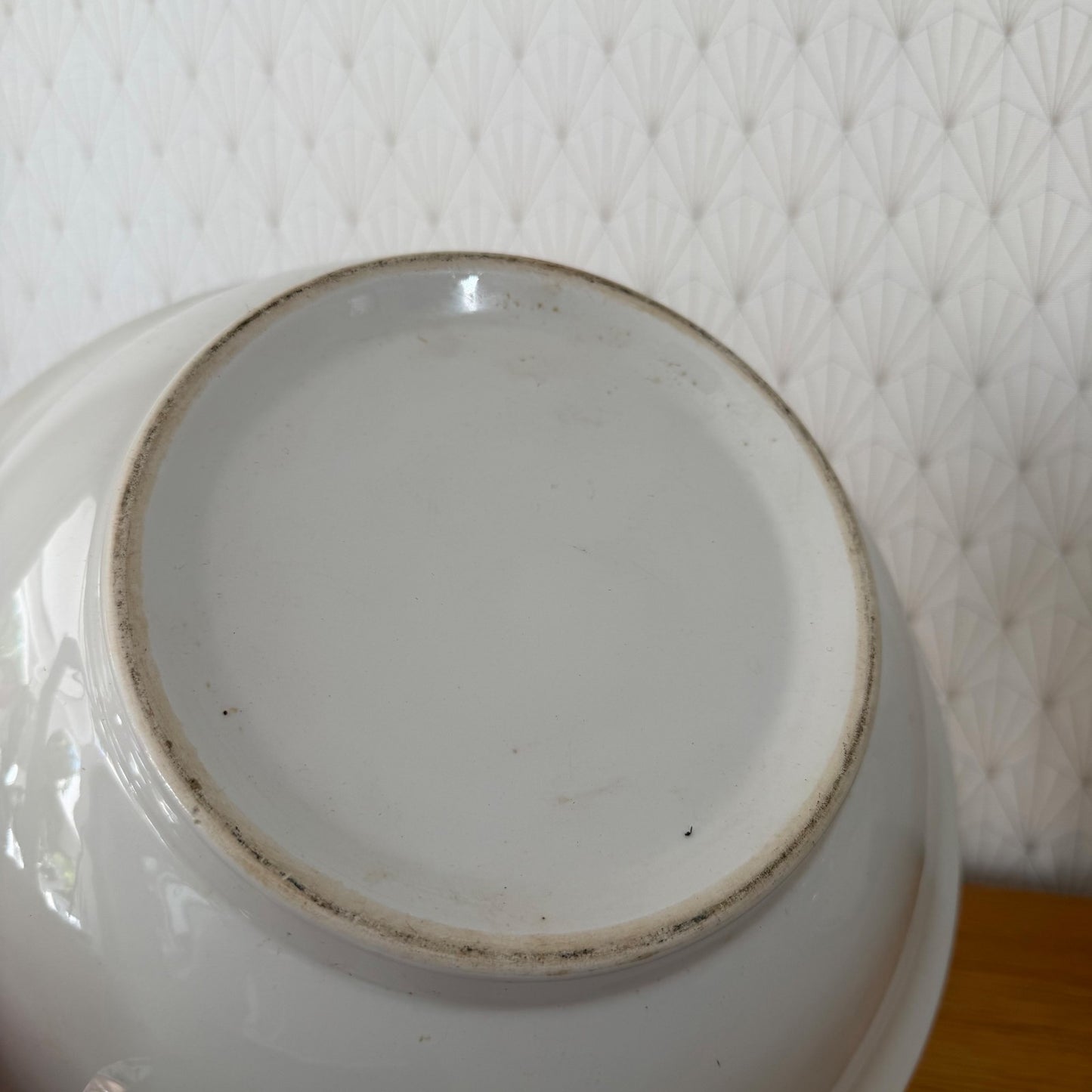Close-up of bowl's interior showing white glaze and maker's mark ring on base