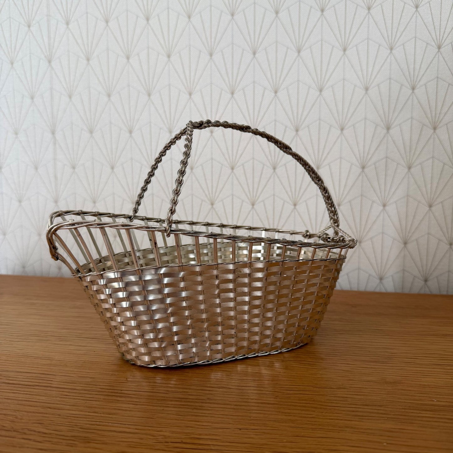 Silver plated wine bottle holder from above showing oval shape and handle attachment