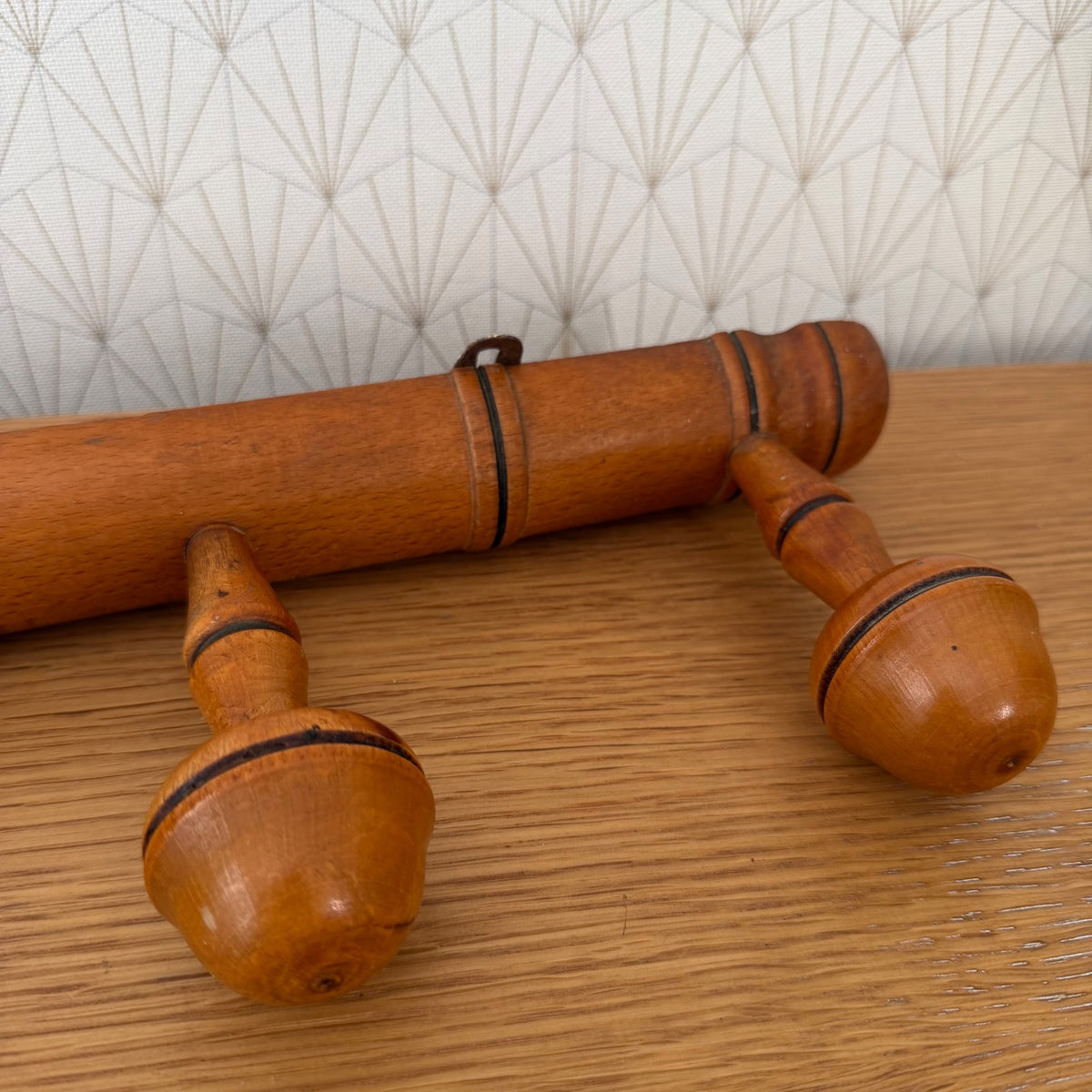 Full front view of vintage French hardwood coat rack with four round wooden pegs, 19 inches wide