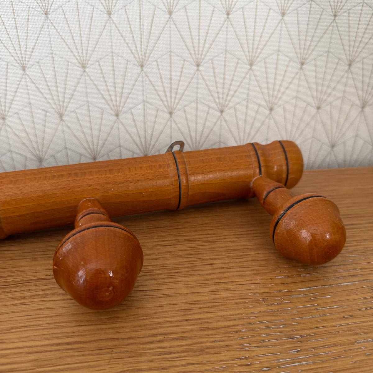 Angled view of mid-century French bamboo coat rack displaying beechwood construction