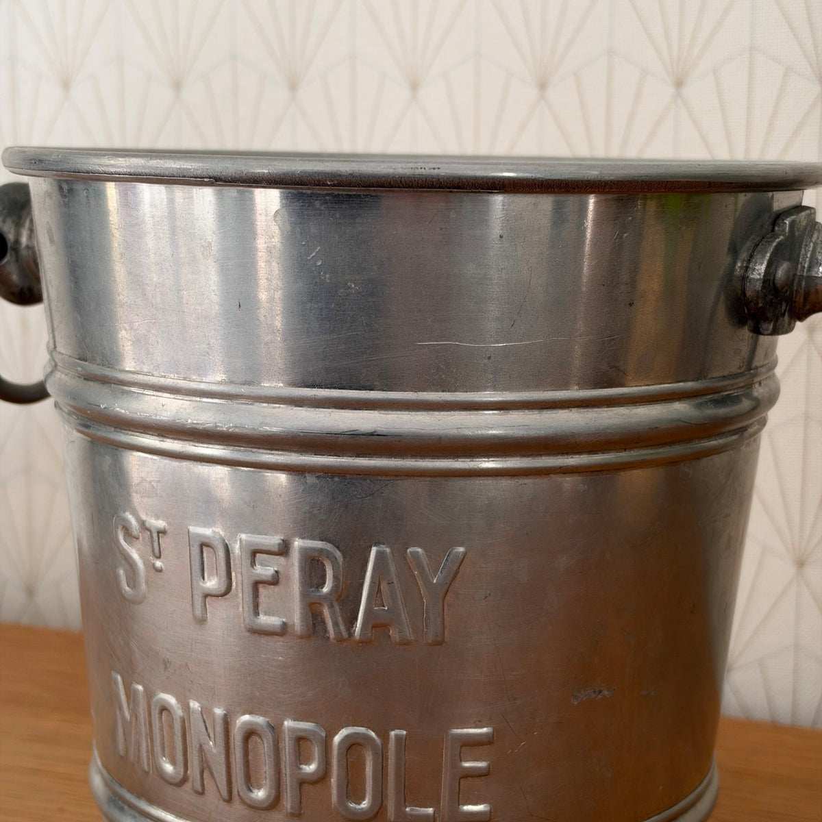 Close-up detail of St Peray Monopole embossed text on vintage French aluminum wine service bucket