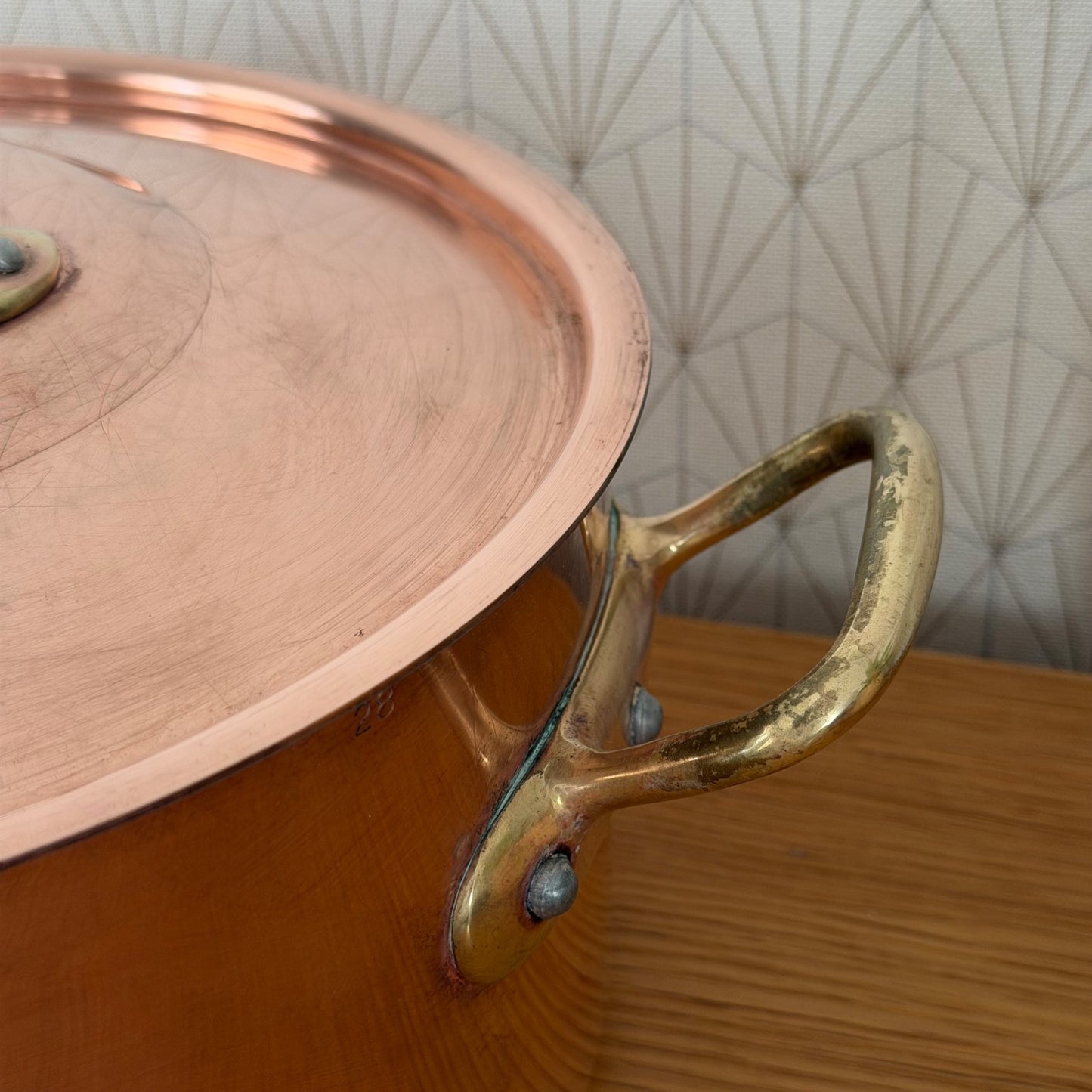 Interior view of heavy-gauge copper stockpot showing cooking surface and riveted handles