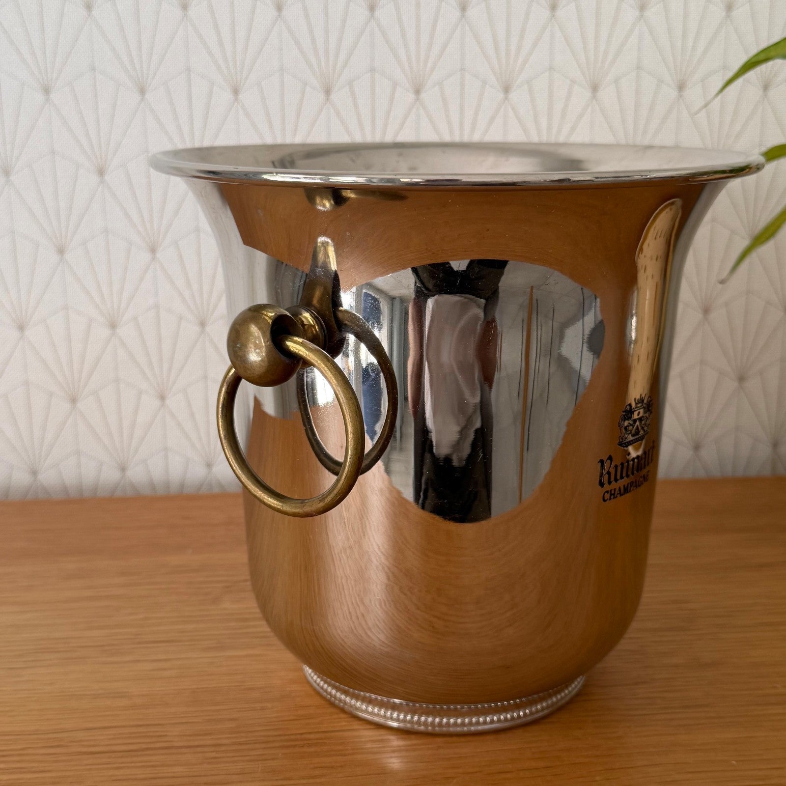 Close-up detail of single brass ring handle on silver-plated ice bucket