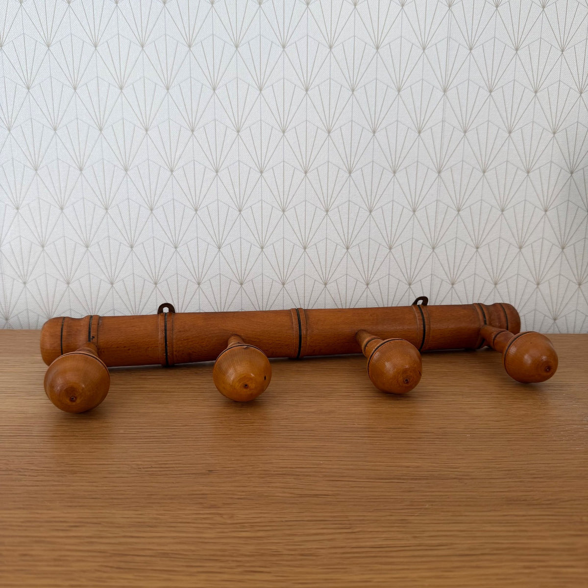 French vintage wood wall coat rack with four turned wooden pegs and iron hanging loops, front view