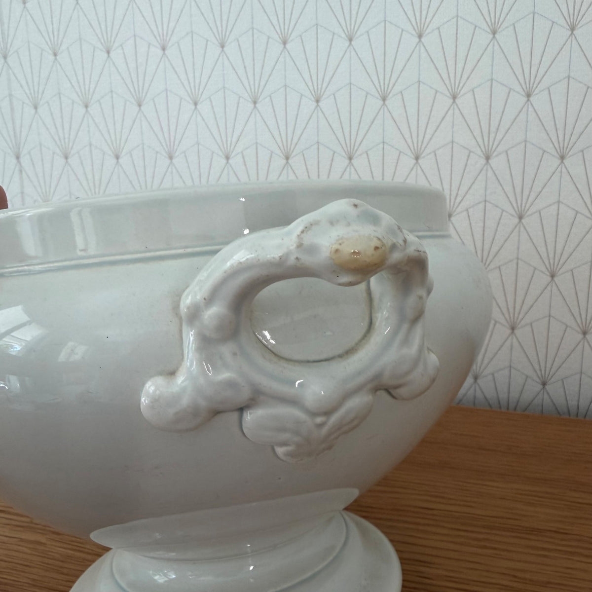 Side profile showing pedestal foot and curved body of antique French tureen