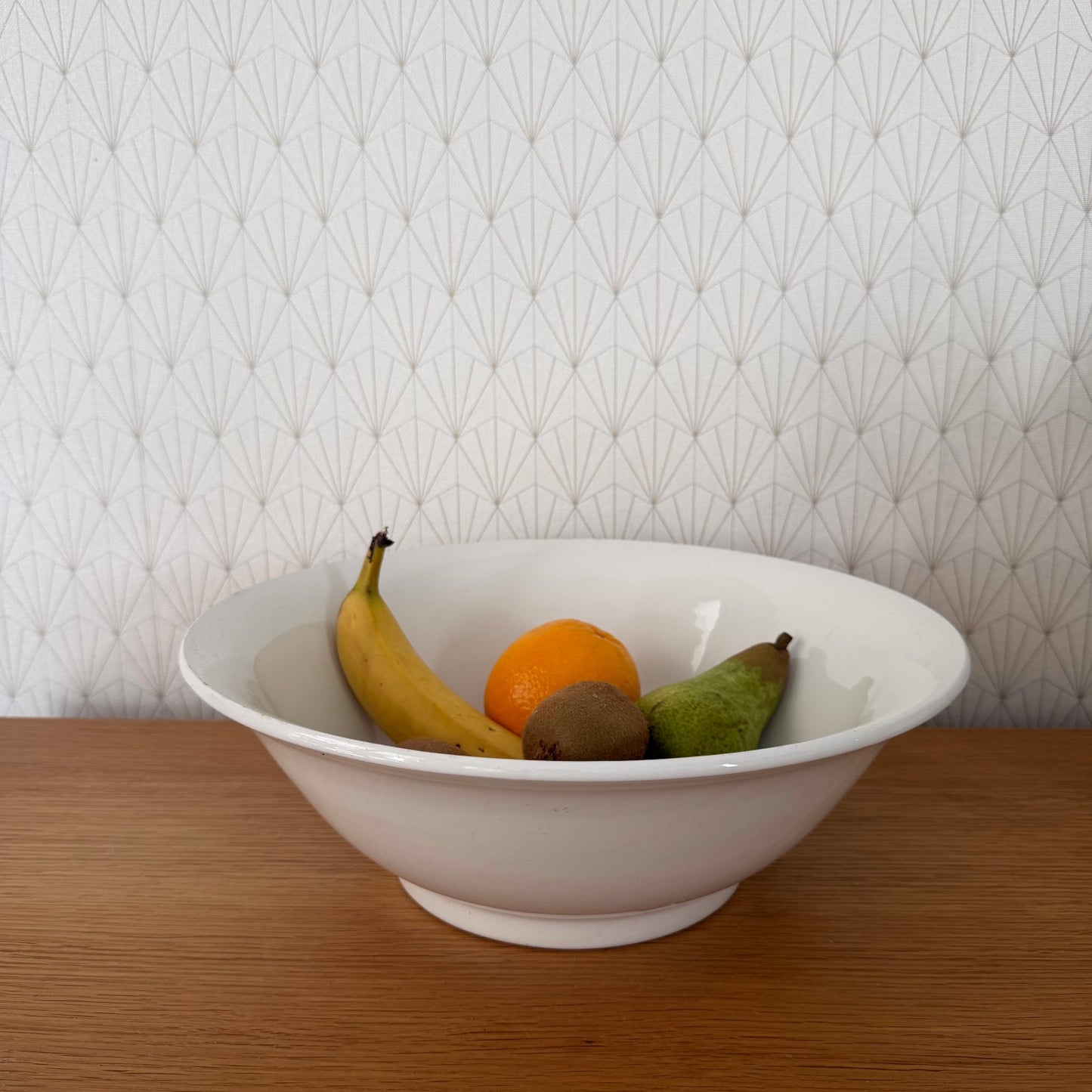 Vintage French white ceramic fruit bowl filled with fresh banana, orange, pear and kiwi fruit