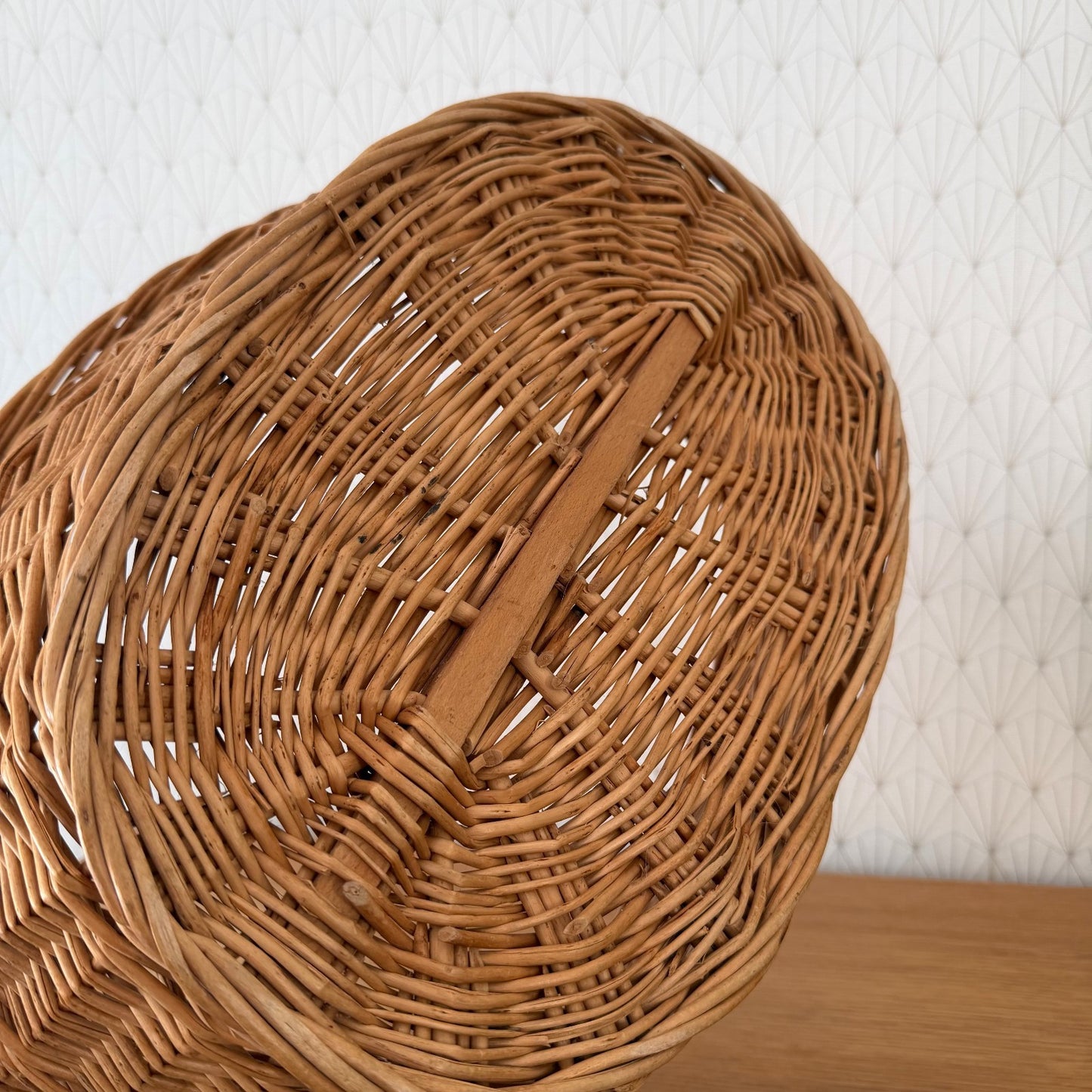 Top-down view showing interior weave structure and wooden support slat of French wicker basket