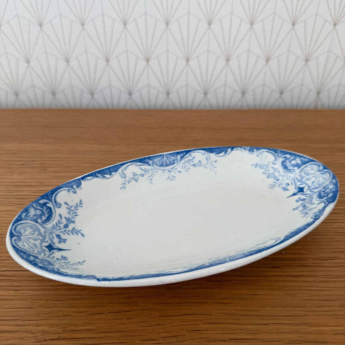 Luneville French faience dish side view showing the curved rim with rocaille cartouche detailing