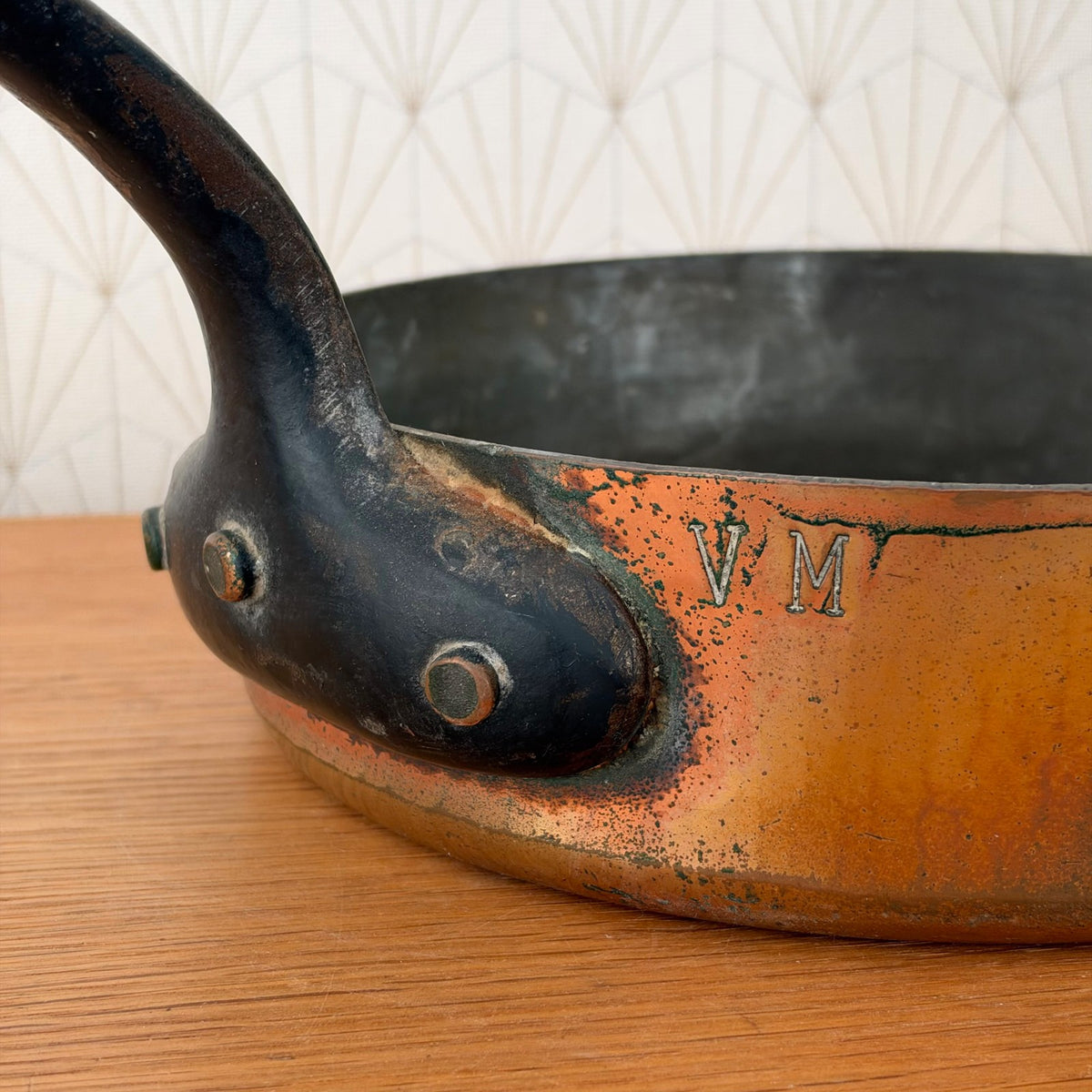 Close-up of E. Dehillerin maker's mark on copper saute pan exterior