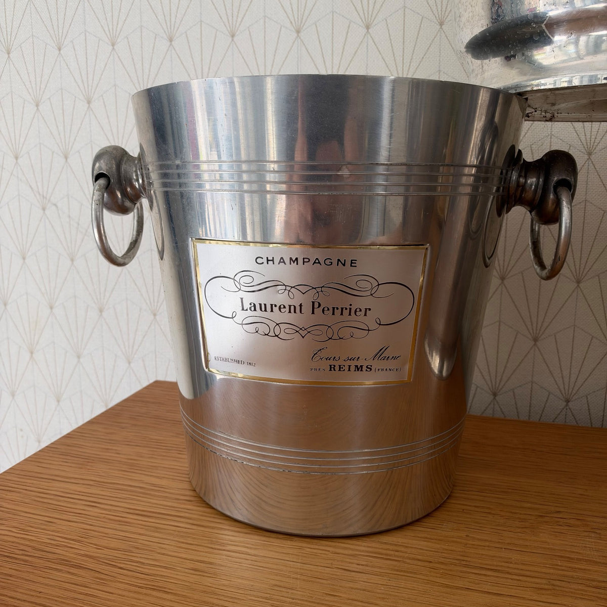 Set of four aluminum champagne buckets lined up showing varied label designs from French champagne houses