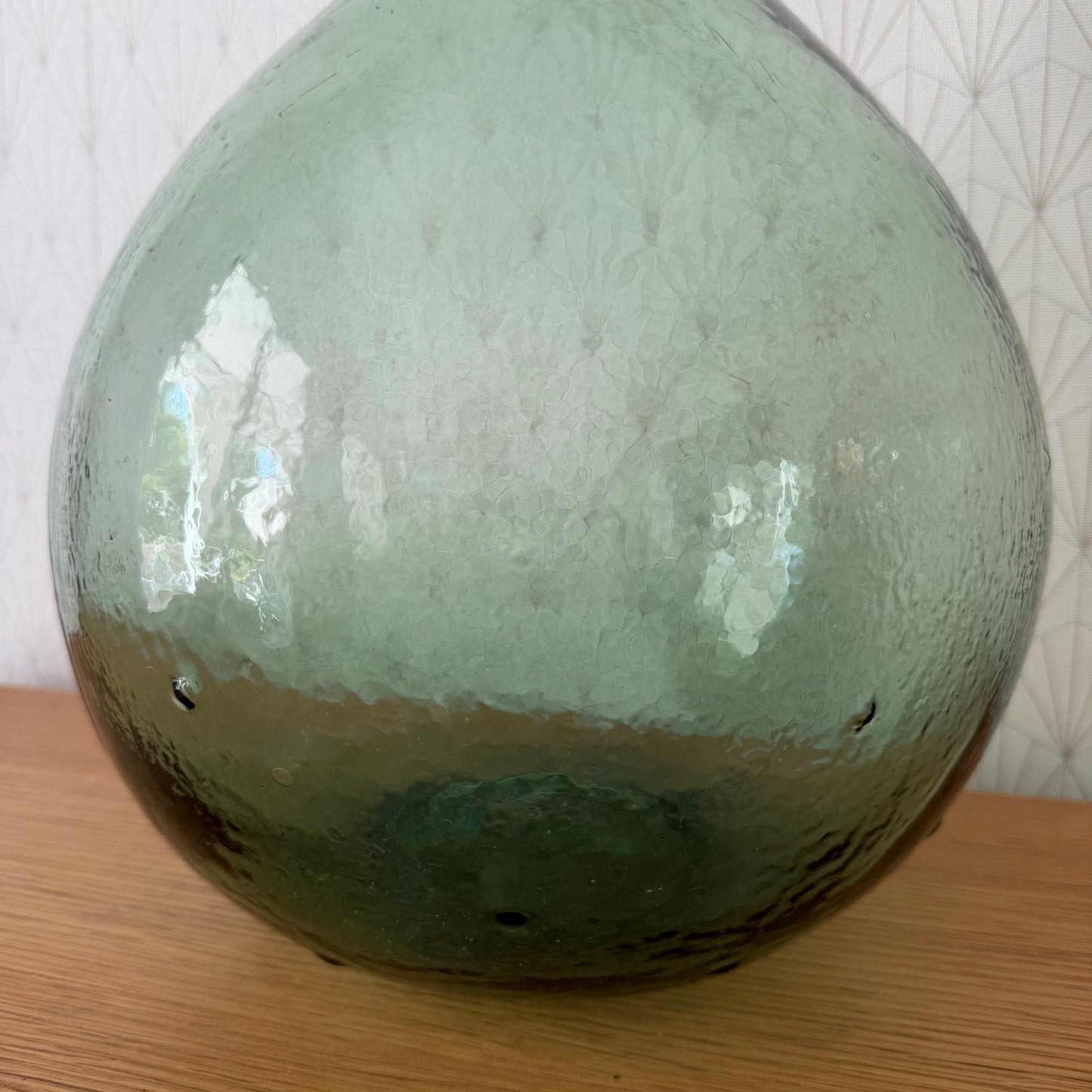 Full body view of antique French Dame Jeanne glass demijohn showing weathered patina