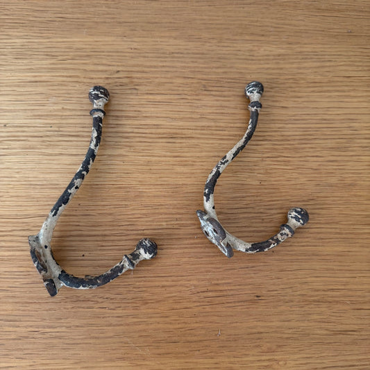 Pair of vintage French folding metal wall hooks with ball finials, flat lay display showing both hook positions