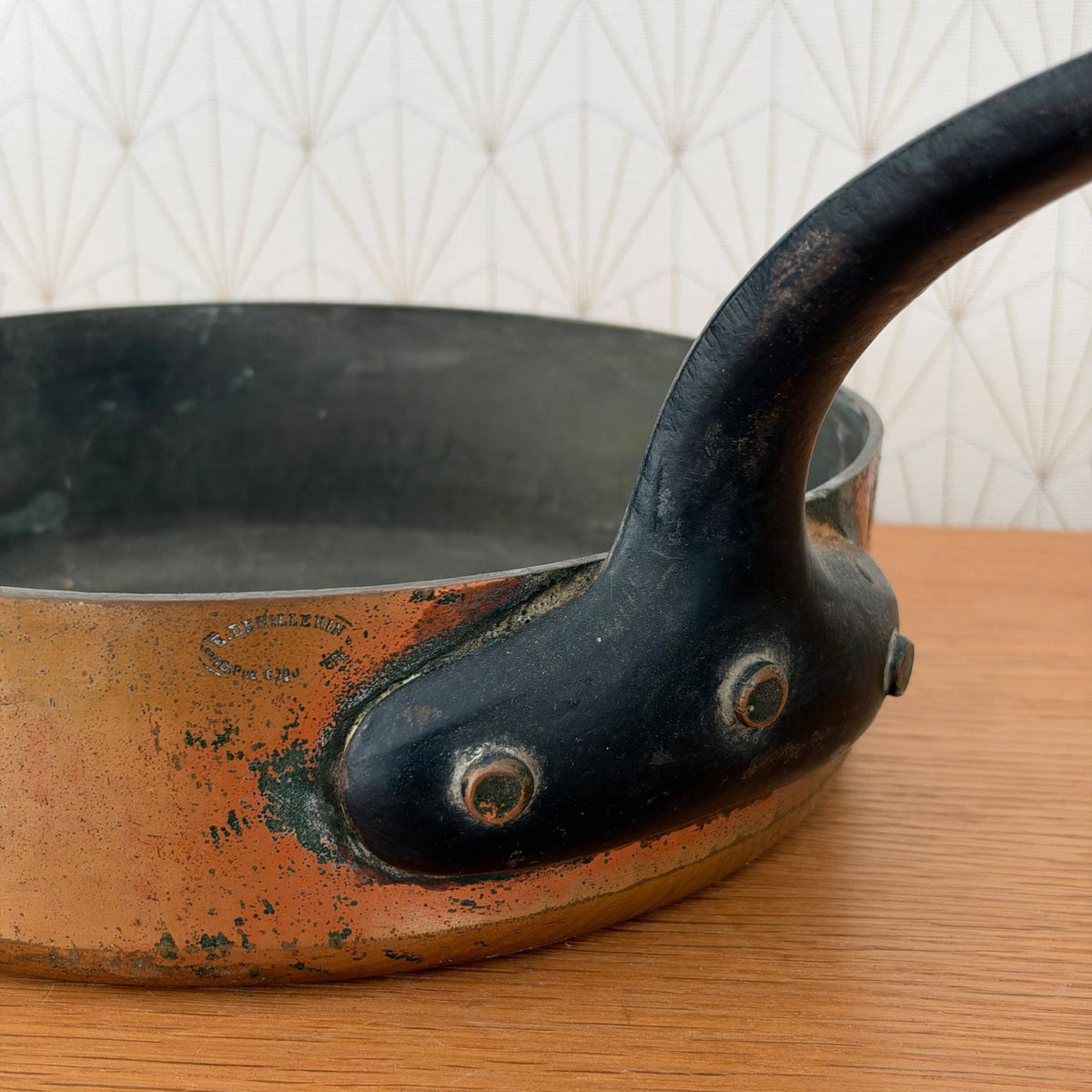 Interior view of dark seasoned copper saute pan showing patina