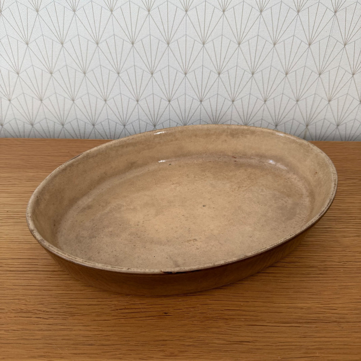 French pottery gratin dish with pale ochre-tan glazed interior, overhead view