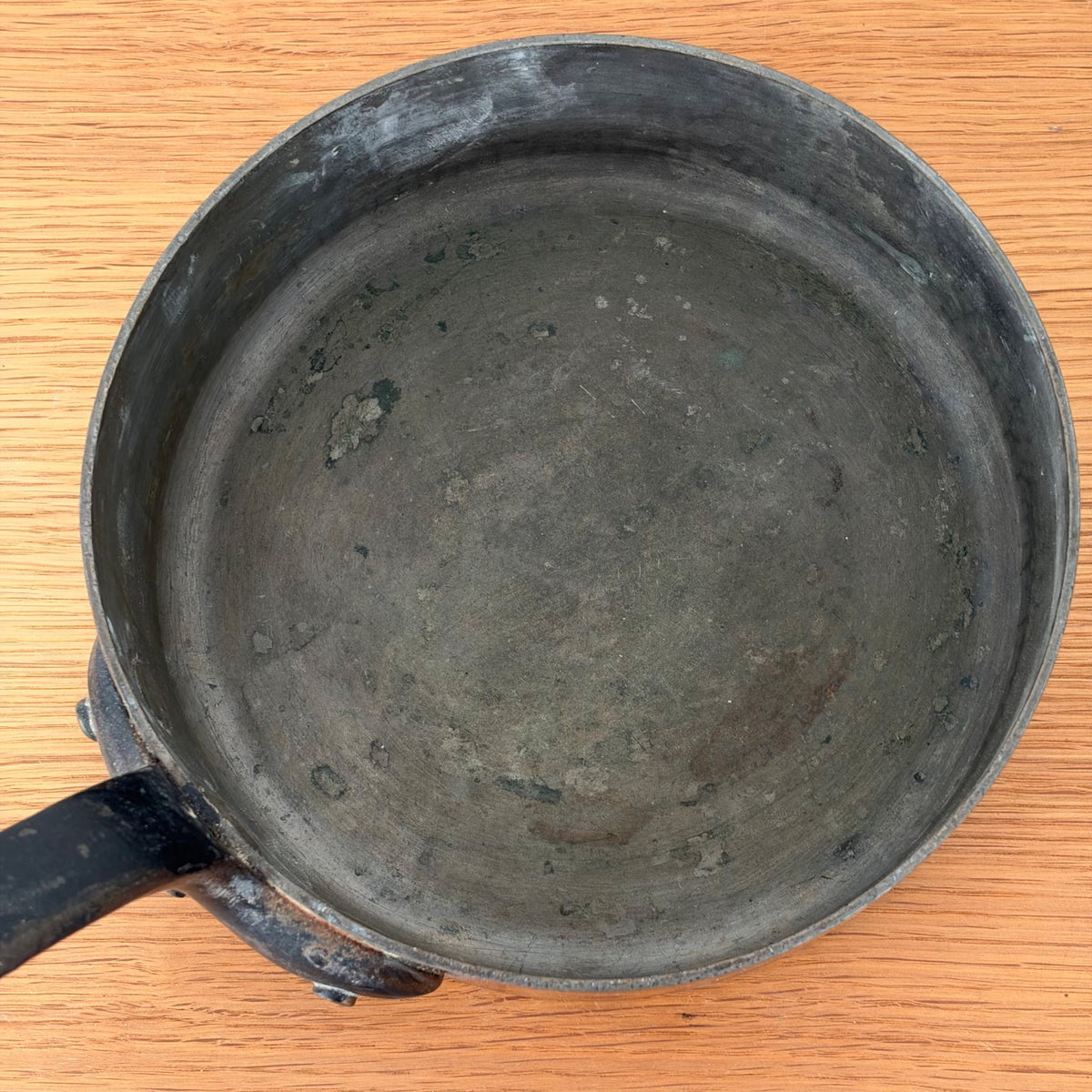 Overhead view of vintage French copper saute pan with iron handle