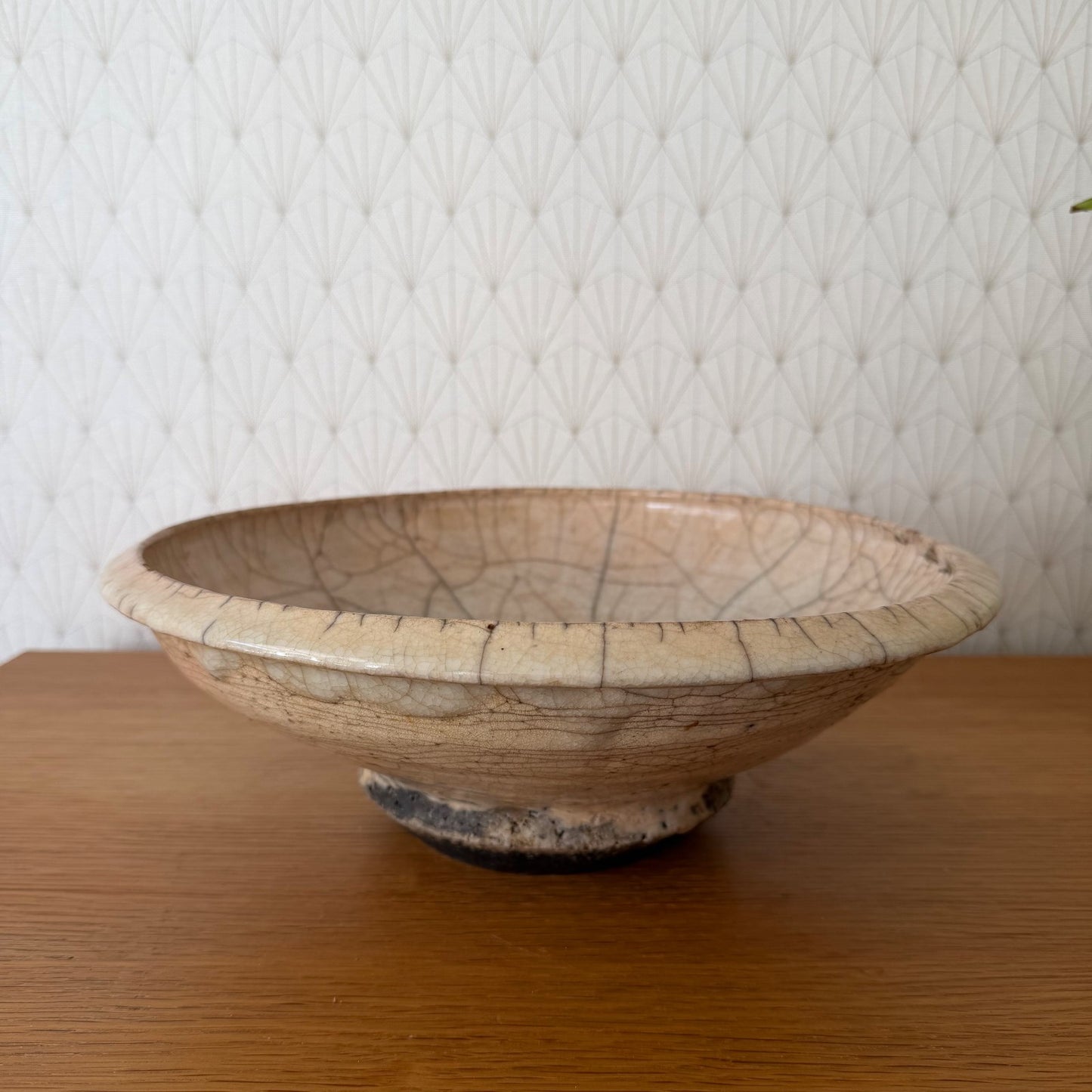 Antique French crackle pottery bowl with footed pedestal base, side view showing pale cream glaze and brown crackle pattern