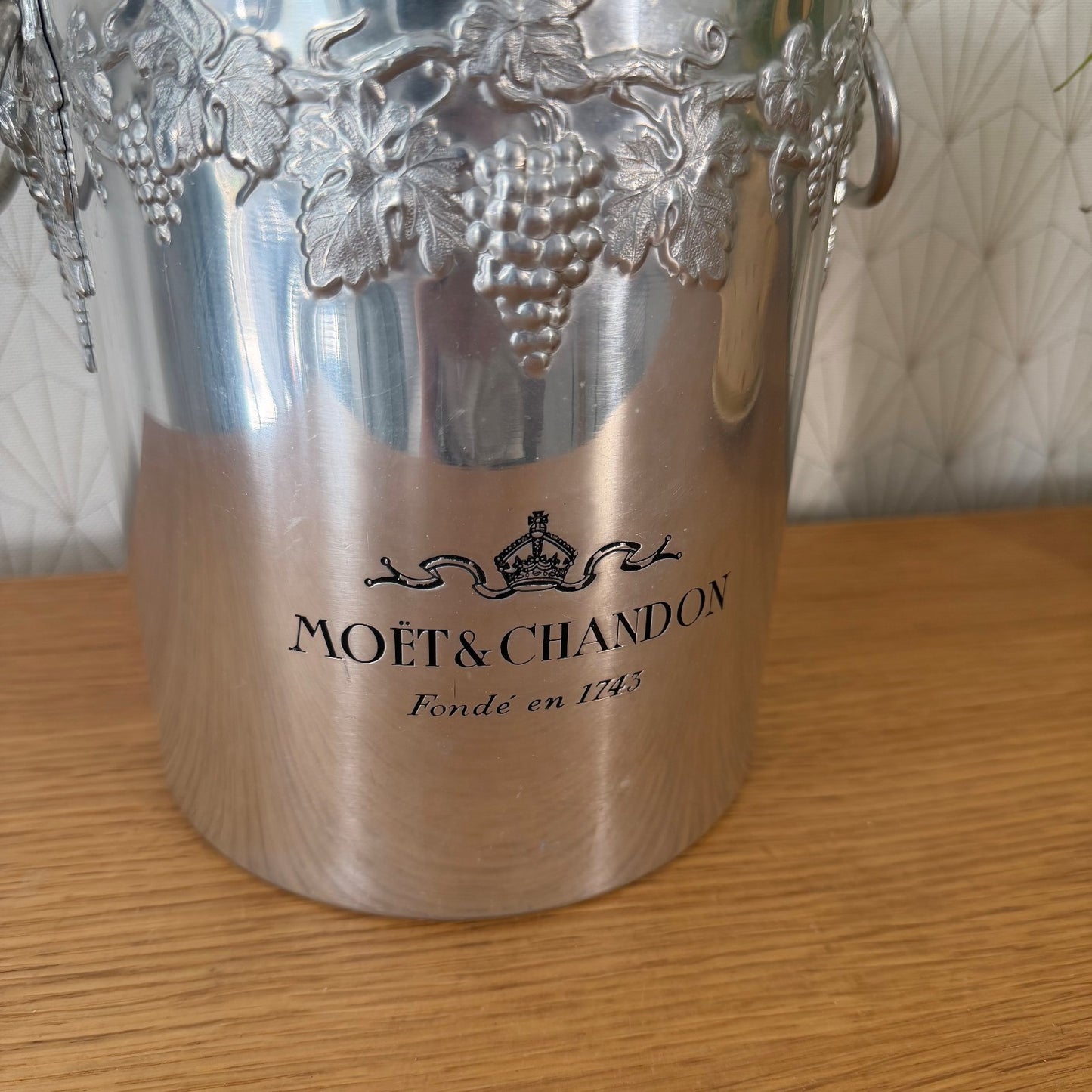 Close-up of embossed grape vine decoration and ring handle on Moet Chandon vintage ice bucket