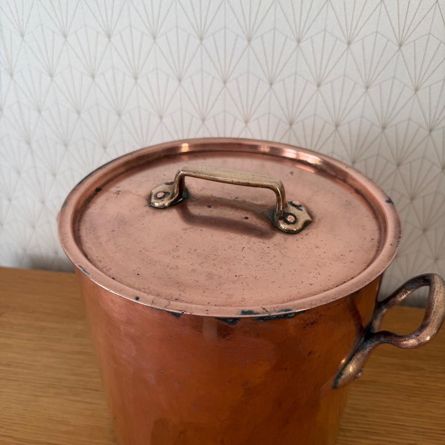 Top view of copper stock pot lid with original brass handles and rim