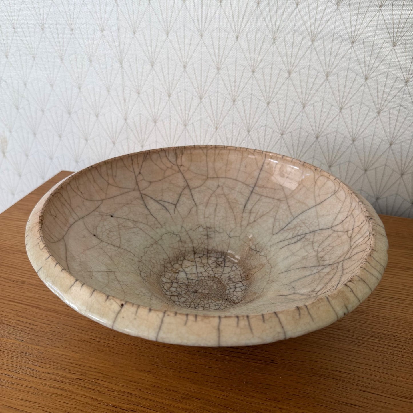 Close-up detail of crackle glaze pattern on antique French pottery bowl, showing fine cracks and darker brown tones
