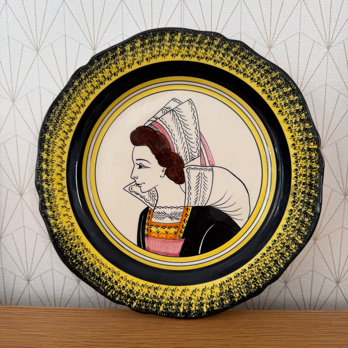 Henriot Quimper woman's portrait plate with yellow speckled border, white lace headdress, and pink ribbon accent