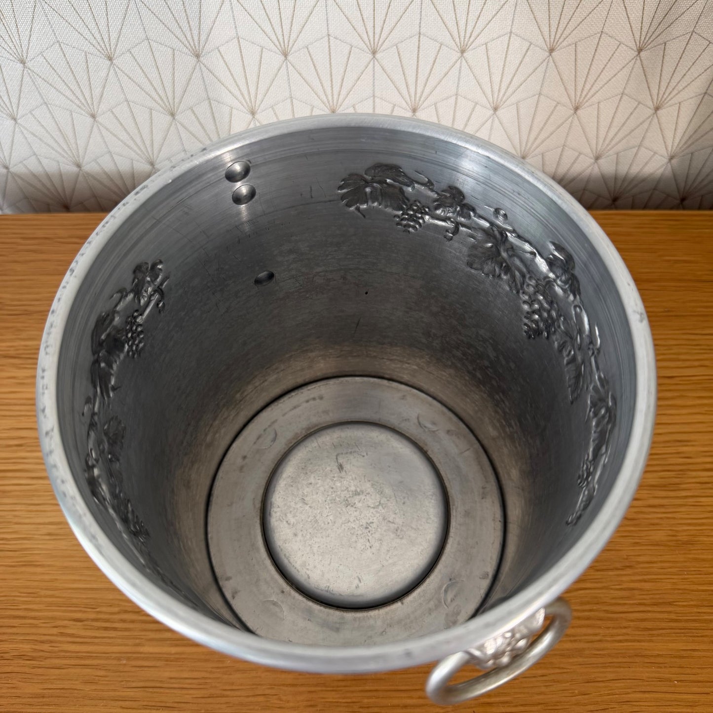 Side detail of Moet Chandon vintage ice bucket displaying handle and decorative grape cluster design