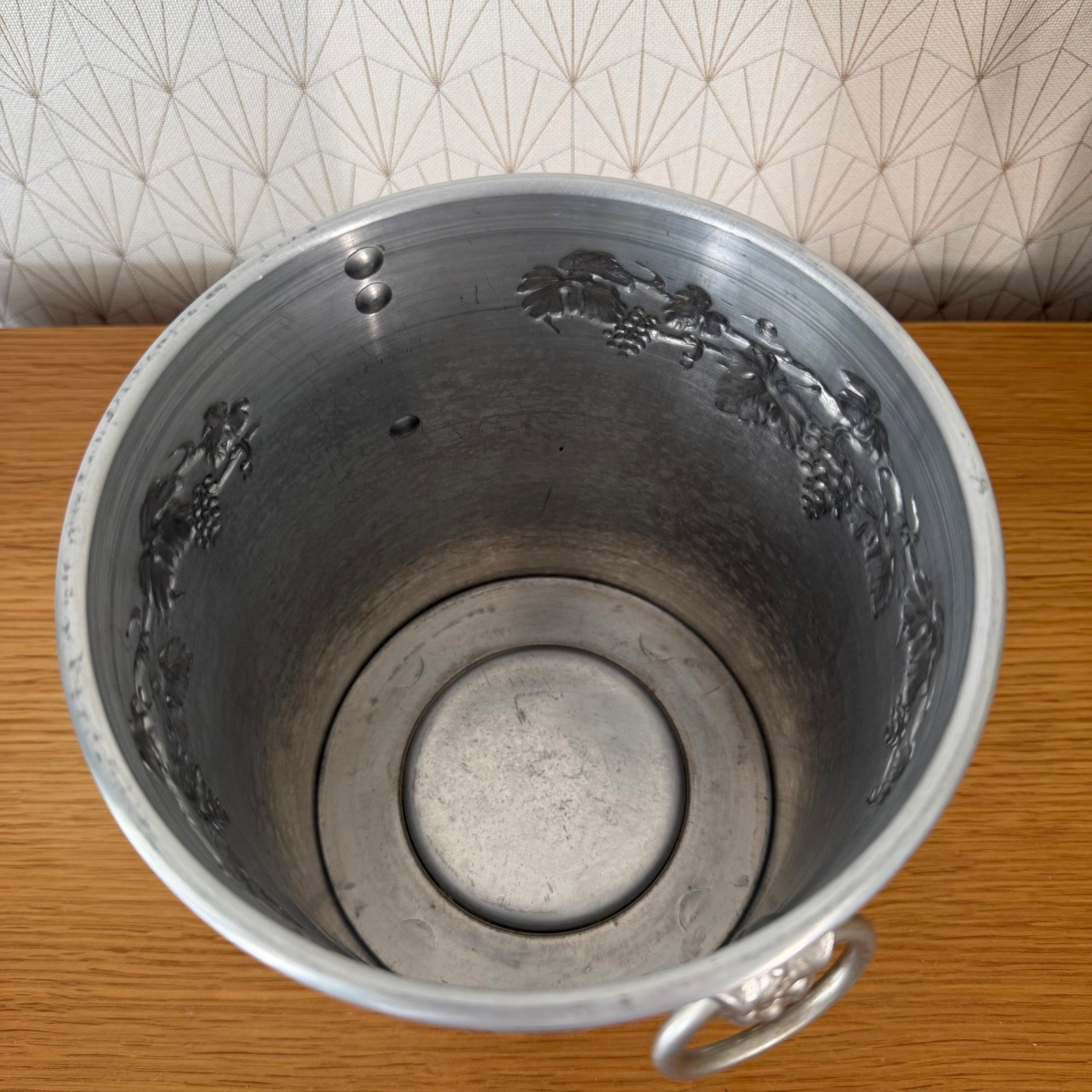 Side detail of Moet Chandon vintage ice bucket displaying handle and decorative grape cluster design