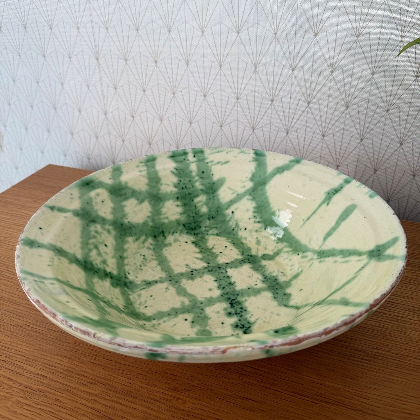 Overhead view of French glazed terracotta tian bowl with organic green leaf patterns
