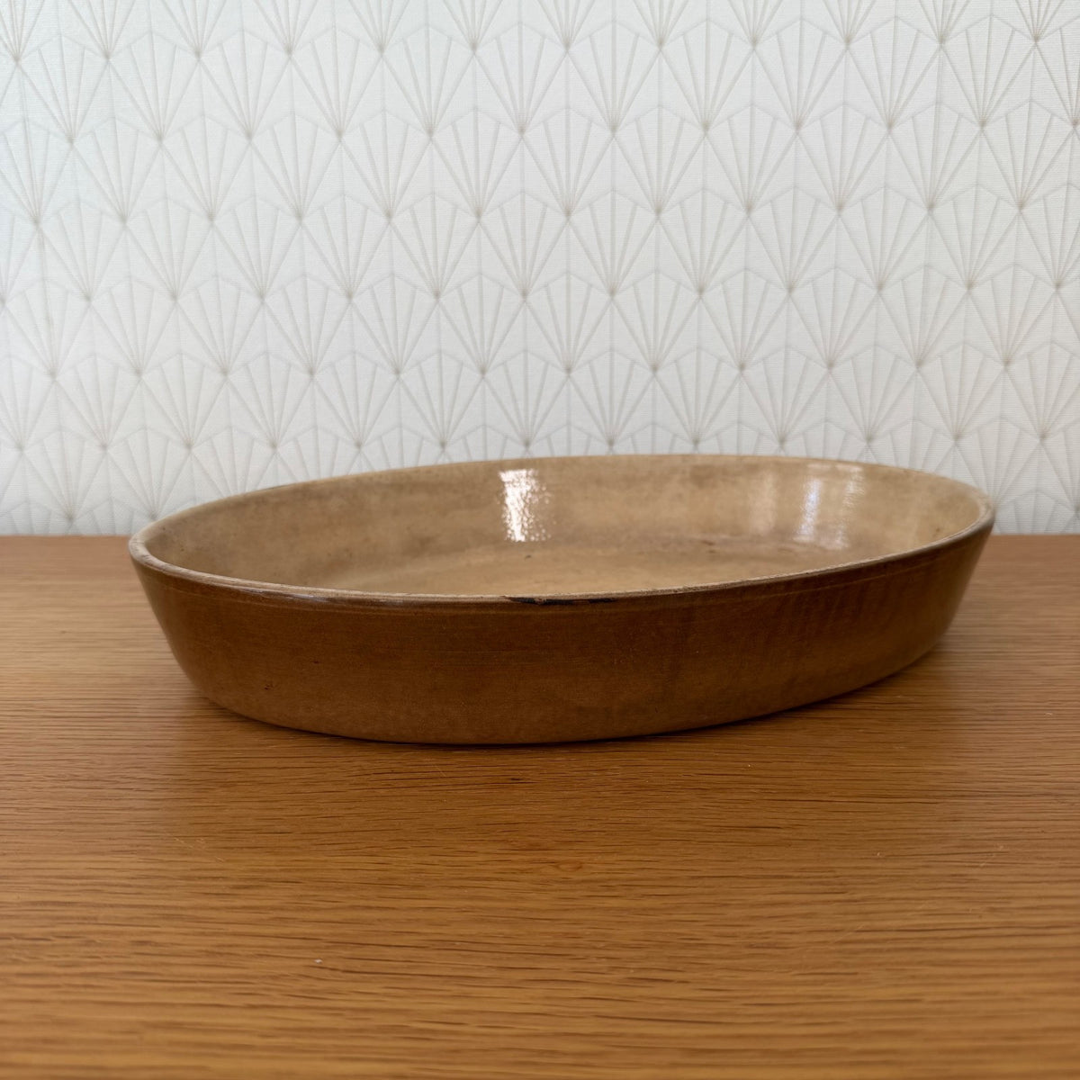Oval French stoneware gratin dish with brown unglazed exterior, side view