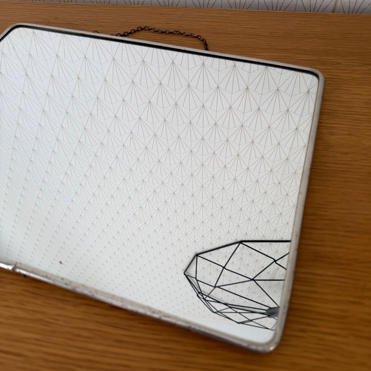 Full frontal view of rectangular Art Deco mirror with geometric pattern reflection in glass