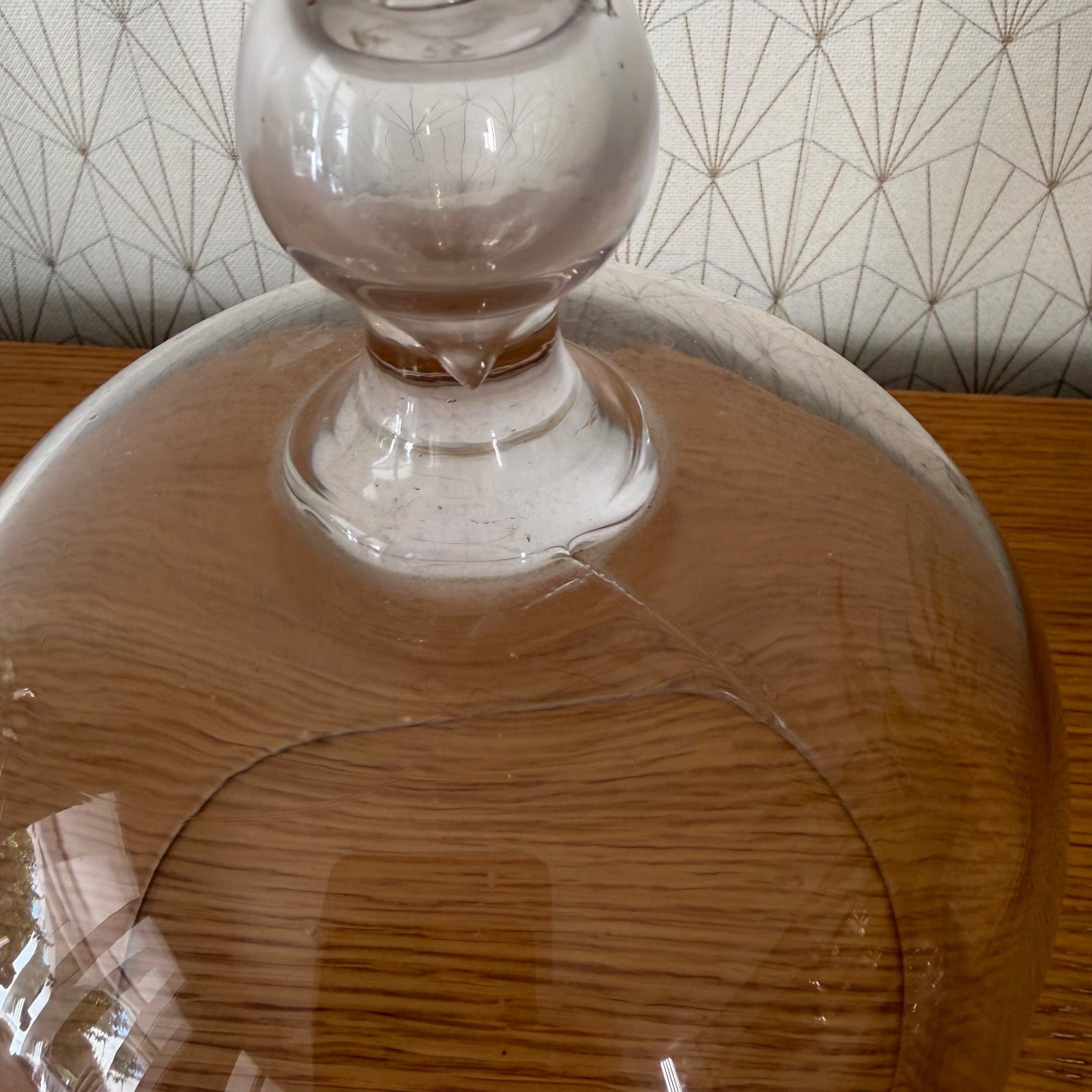 Detail of glass cloche dome base showing maker marks and hand-formed pedestal foot