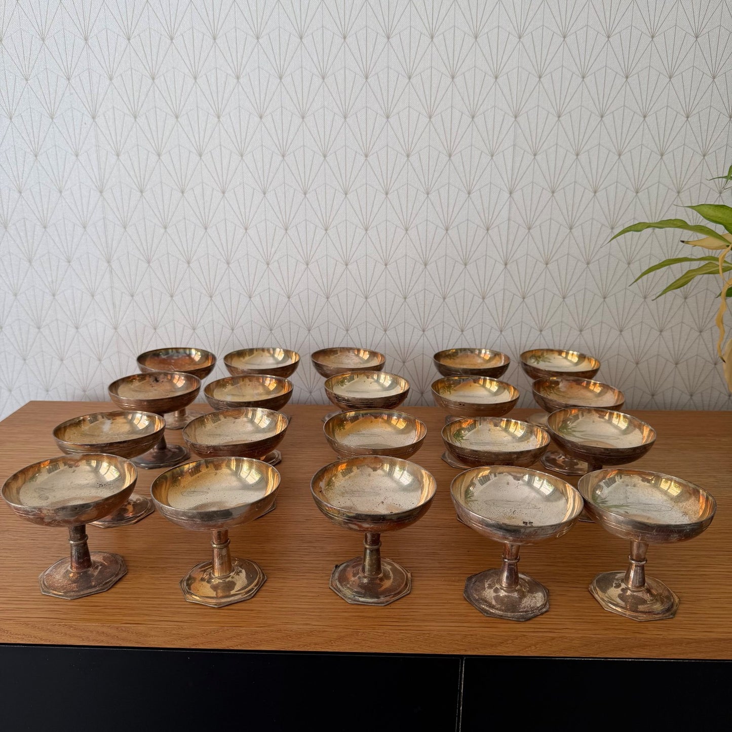 Close view of vintage silverplate champagne coupes showing pedestal stems and patinated bowls from institutional service